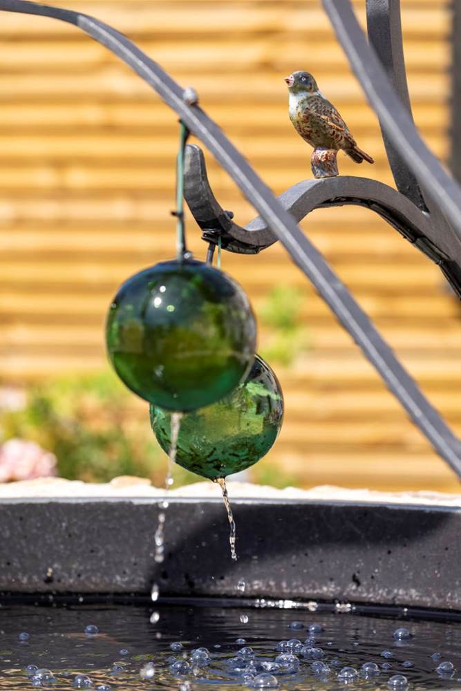 Les boules de verre comme en suspension, laisse s'écouler l'eau de la fontaine ©